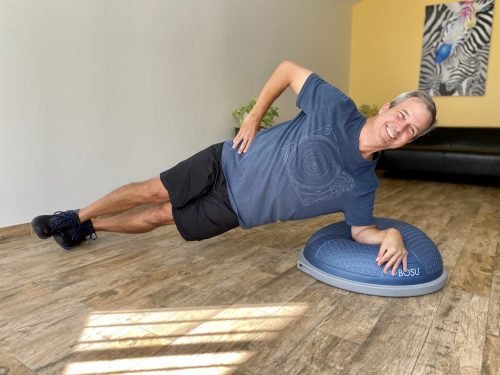 Man in a side plank on the Bosu ball